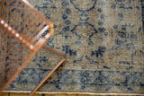Distressed Oushak rug pile, revealing faded cobalt blue floral motifs and worn foundation.