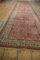 Angled view down the length of a distressed Malayer runner showing its low-pile texture.