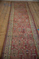 Angled perspective down the length of a distressed Malayer runner with a repeating boteh design.