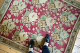 Antique Karabagh rug's raspberry red rose bouquet field and starburst border with even wear.