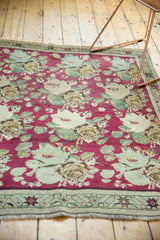 Antique Karabagh rug's raspberry rose bouquet field, even wear, and starburst border.