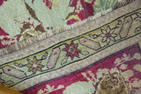 Traditional Karabagh rug border detail with starburst pattern in raspberry red, pale bronze, and ivory.