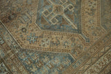 Distressed Kamseh carpet detail: beige and dusty blue geometric motifs with faint foundation showing.