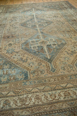 Distressed vintage Kamseh rug with faded sand, beige, and dusty blue geometric motifs.