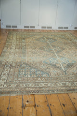 Distressed vintage Kamseh carpet section, showing geometric motifs in muted beige, blue, and coffee tones.
