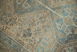 Distressed Kamseh rug with faded beige, dusty blue, and intricate abstract patterns.