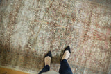 Distressed vintage Isfahan rug displaying faded tree of life pattern and pale yellow silk details.