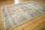 Secured side of a distressed vintage Isfahan rug, with worn pale yellow silk and blush details.