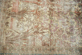Intricate pale yellow silk and blush floral motifs of a distressed vintage Isfahan rug.