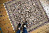Distressed vintage Sparta rug corner with navy trellis vinery and blush pink turtle border.