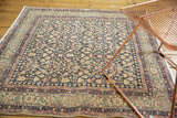 Distressed vintage Sparta rug corner showing time-softened blush pink and navy turtle border.