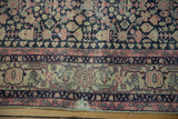 Distressed Sparta rug corner with worn navy, ivory, and blush pink turtle border.