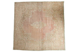 Distressed vintage Kerman square carpet featuring a faded blush pink field and ornate floral medallion.