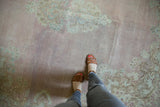 Distressed Kerman square carpet, blush pink field, Rococo floral motif, and visible foundation.