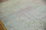 Distressed vintage Kerman carpet with faded blush field and Rococo floral motifs.