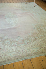 Vintage distressed Kerman carpet corner: Rococo floral relief in blush pink and seafoam.