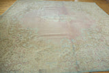 Distressed Kerman carpet with intricate Rococo floral patterns in muted rose and seafoam.