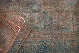 Vintage distressed Tabriz carpet featuring powder blue and red floral vinery with storied wear.