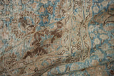 Distressed vintage Tabriz rug pile, showing scrolling vinery in ocean blue, beige, and brown.