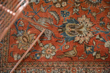 Vintage Qom carpet: brick red field with Safavid animal forest scene, palmettes, and border.