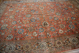 Ivory border detail on vintage Qom carpet with brick red field, palmettes, and animal scene.