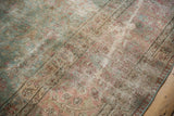 Faded powder blue and dusty raspberry floral vinery on distressed Tabriz rug texture.