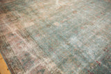 Angled detail of vintage distressed Tabriz rug, intricate faded floral vinery, and worn pile.