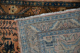 Corner of a vintage Persian Lilihan rug showing its hand-knotted back and front pile.