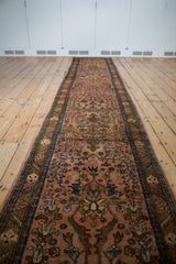 Low angle perspective showing the full length of a vintage Lilihan rug runner in dusty rose.