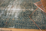 Distressed vintage Lilihan rug with exposed knot heads and faded teal floral designs.