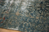 Worn pile and exposed foundation on a distressed Lilihan rug with faded teal and ivory patterns.