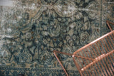 Distressed vintage Lilihan rug showing worn pile, exposed foundation, and dusty teal floral motifs.