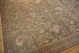 Angled view of the vintage Malayer carpet's distressed texture, with scrolling vines and botehs in olive and sand.
