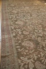 Side perspective of a vintage Malayer carpet highlighting its scrolling boteh motifs and time-softened olive tones.