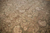 Close-up on the distressed pile, revealing the scrolling vines and botehs in muted olive and sand tones.