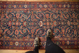 Intricate Herati motif and floral border in navy, madder red, and blue on antique Bijar rug.