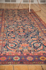 Antique Kurdish Bijar rug runner's restored end border, showing madder root red, blue floral design, and fringe.