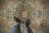 Distressed antique Farahan Sarouk rug, showing even wear on faded dusty teal and terracotta patterns.