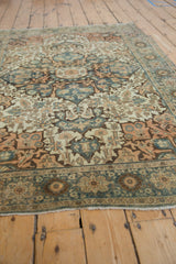 Distressed Farahan Sarouk rug's dusty teal, terracotta, ivory floral patterns with worn pile and fringe.