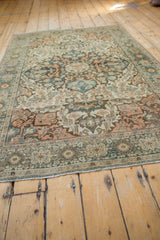 Antique Farahan Sarouk rug corner showing distressed floral border, soft tones, and fringe.