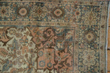 Antique Farahan Sarouk rug's corner spandrel with distressed teal, blush, and ivory floral patterns.