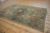 Antique Farahan Sarouk rug corner: distressed dusty teal border, intact selvage, and visible wear.