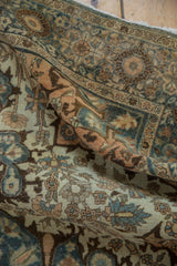Crumpled antique Farahan Sarouk rug with distressed floral pattern in dusty teal and terracotta.