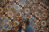 Hand-knotted vintage Bibikabad carpet with repeating navy, blue, and sand floral medallions underfoot.