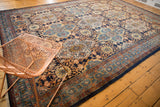 Navy and sky blue quatrefoil medallions with floral border on vintage Bibikabad carpet.