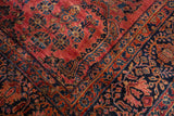 Vintage Sarouk rug corner features dusty raspberry field and navy blue floral border.