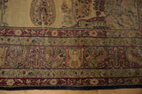 Antique Kermanshah carpet detail: cochineal red borders with floral patterns and worn camel field.