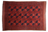 Vintage Ersari carpet with repeating geometric medallions in chestnut red, navy, and cobalt blue.