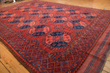 Vintage Ersari carpet's geometric border detail in deep chestnut brick red and navy blue.