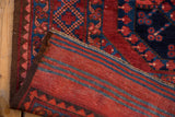 Vintage Ersari carpet's deep red and navy geometric pile, striped plain weave back, and selvage.